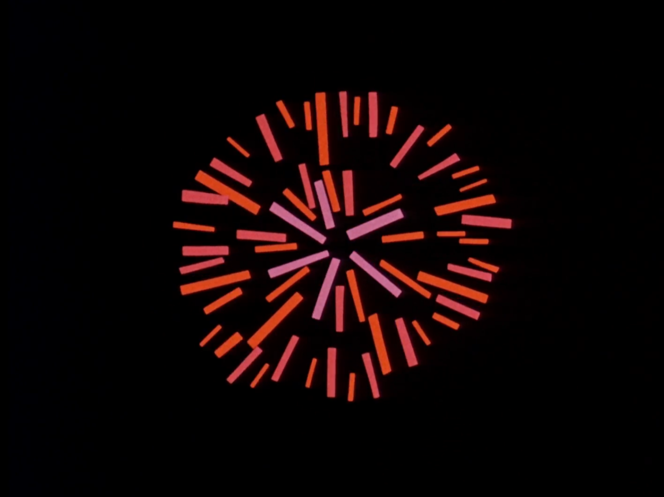 still from paper cut animation depicting red and pink scraps of paper on a black background fanning out like a firework