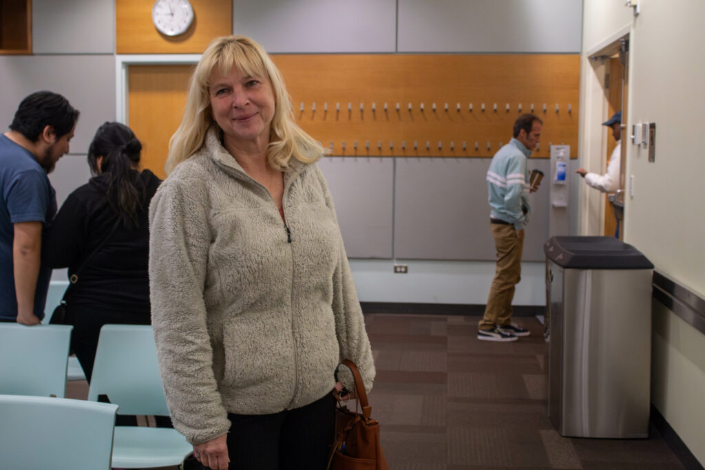 photo of a woman standing and smiling at the camera