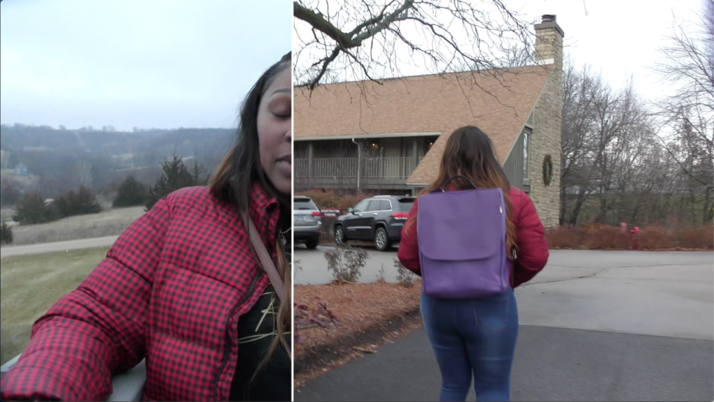 film still in the middle of a wipe transition from one medium shot of a woman on a porch to a medium wide shot of the same woman walking toward a cabin