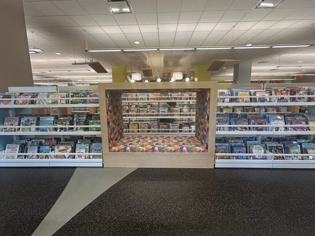 Children's shelving with a colorful, cushioned reading nook built into the center.