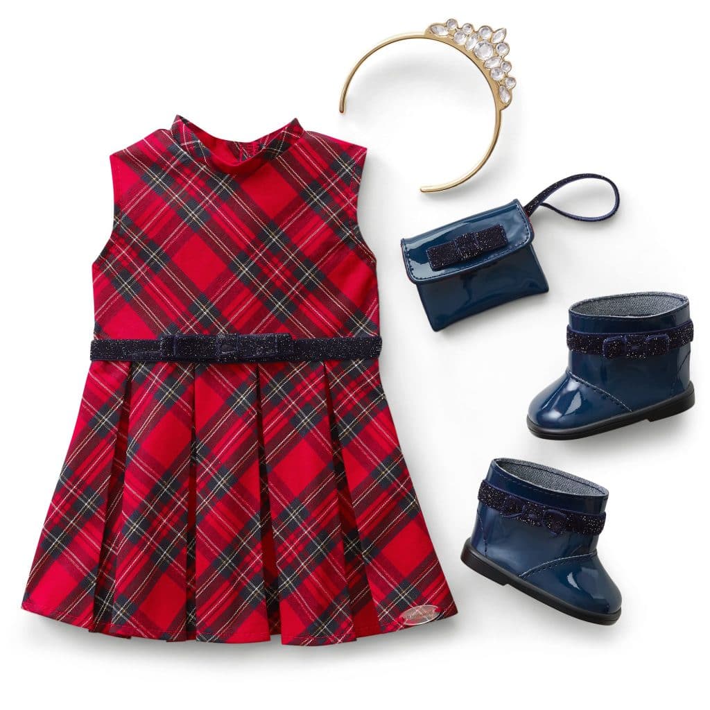 A red plaid sleeveless dress with a matching belt, navy boots, a navy purse, and a gold tiara headband with faux jewels, all arranged on a white background.