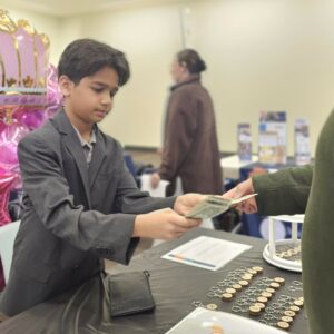 A boy in a suit hands exchanges money with buyer