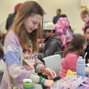 A girl makes colorful bracelets