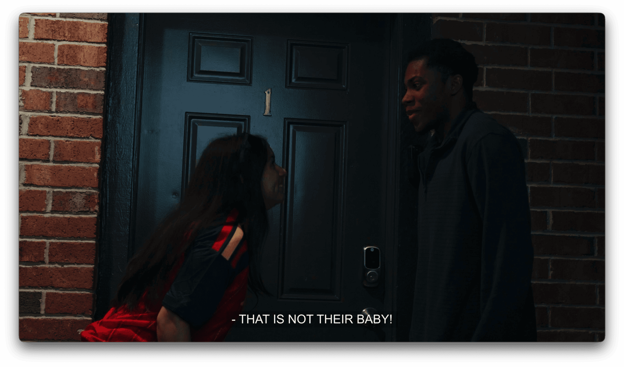 A woman and a man shout in unison in front of a dark door labeled